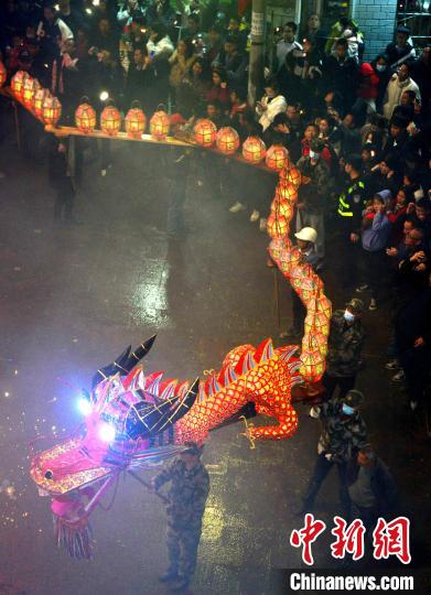 图为刻纸龙灯巡游吸引了许多民众前来观赏。 张斌 摄 图为刻纸龙灯巡游吸引了许多民众前来观赏。 张斌 摄