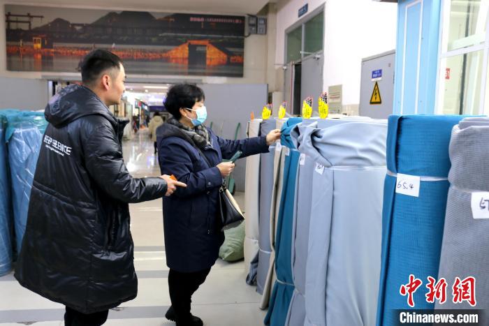采购商与经营户洽谈面料生意 项菁 摄 采购商与经营户洽谈面料生意 项菁 摄