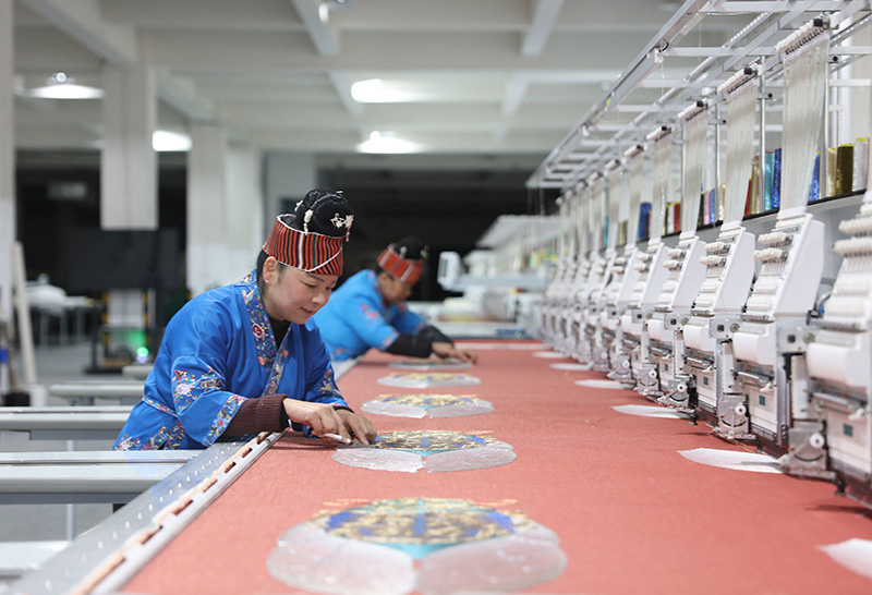 2023年2月13日,贵州省黔东南苗族侗族自治州施秉县工业园区,工人在机绣车间作业。
