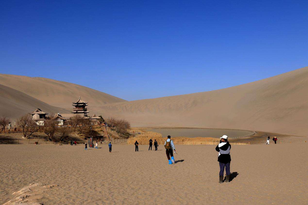 游客在敦煌鸣沙山月牙泉景区游览