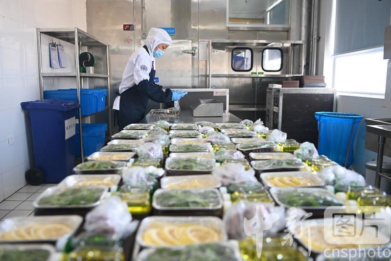 图为工作人员对餐食进行封膜包装。 中新社记者 九美旦增 摄 图为工作人员对餐食进行封膜包装。 中新社记者 九美旦增 摄