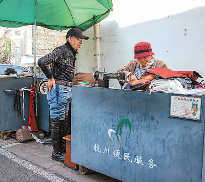 浙江省杭州市让“小修小补”的便民店铺规范有序回归百姓生活。图为西湖区北山街道便民服务摊位,裁缝师(右)为社区居民修补衣物。 新华社记者 江 汉摄 浙江省杭州市让“小修小补”的便民店铺规范有序回归百姓生活。图为西湖区北山街道便民服务摊位,裁缝师(右)为社区居民修补衣物。 新华社记者 江 汉摄