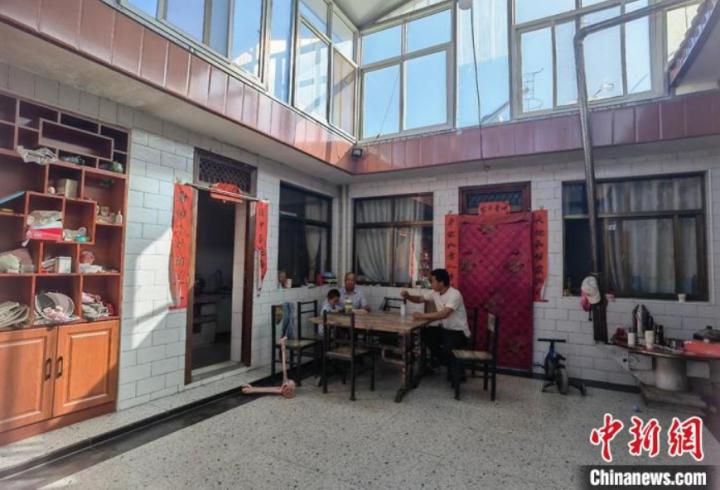 图为富坪村村民张霞科与老人孩子在院子里闲聊。 刘玉桃 摄 图为富坪村村民张霞科与老人孩子在院子里闲聊。 刘玉桃 摄