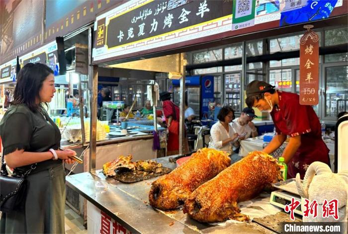 和田夜市上的新鲜烤全羊出炉。 闫兆霞 摄 和田夜市上的新鲜烤全羊出炉。 闫兆霞 摄