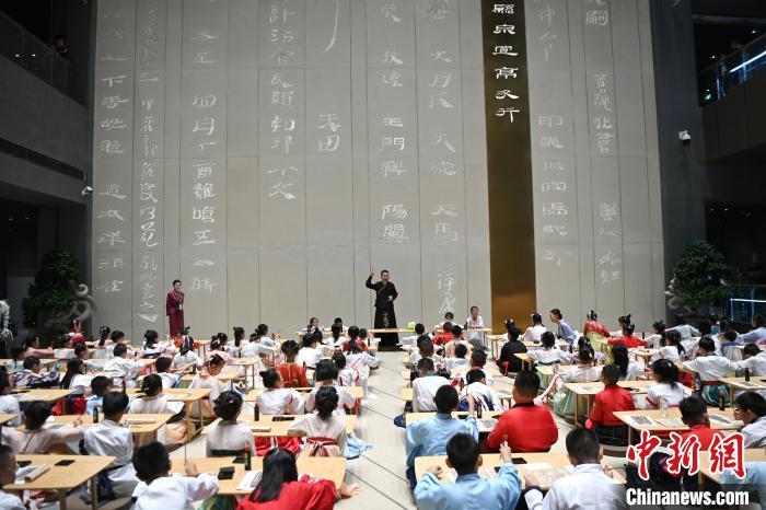 图为9月7日，甘肃简牍博物馆开馆仪式在兰州举行，小朋友们学习书写简牍中的文字。　中新社记者 九美旦增 摄