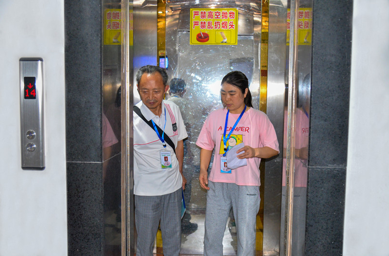 牌楼街道大河沟社区,物业长、楼栋长排查居民反映的电梯安全问题。付作侨摄