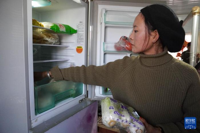 ？？1月16日，在甘肃省临夏州积石山县刘集乡阳洼村安置点的板房内，群众从冰箱内拿取蔬菜准备做饭。新华社记者 马希平 摄