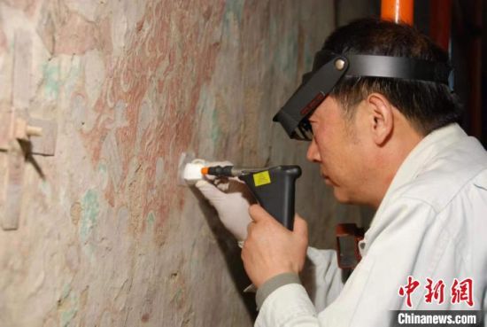 敦煌研究院研究员樊再轩进行壁画修复。(资料图)张云文 摄 敦煌研究院研究员樊再轩进行壁画修复。(资料图)张云文 摄