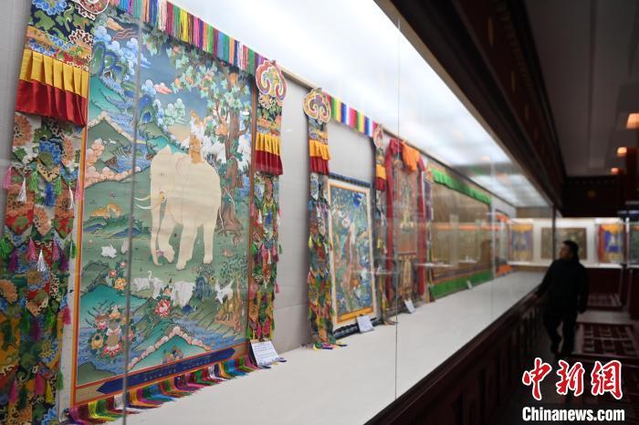 距离唐卡小镇数十米远的精品唐卡展厅，摆满了甘南藏族唐卡国家级代表性传承人交巴加布与父亲二人的作品。图为交巴加布与父亲的唐卡作品吸引游人“打卡”。九美旦增 摄</p>
<p>