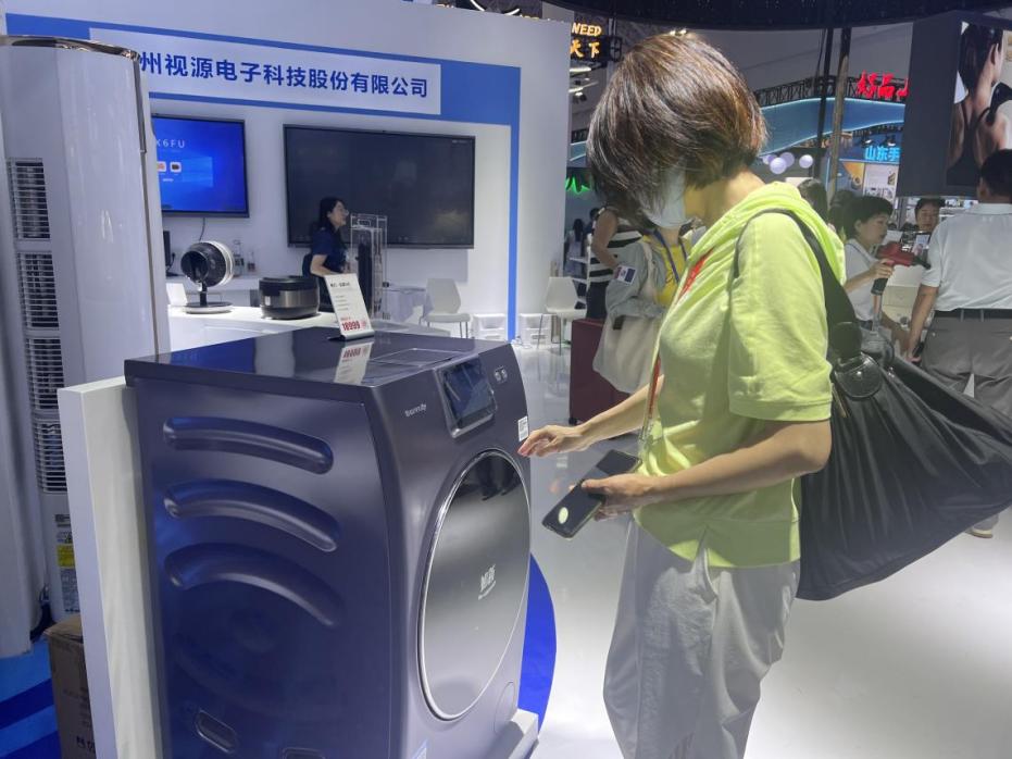 在广东馆展区内,观展者正在了解家用电器性能。人民网记者 杨迪摄
