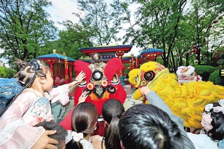 国庆假期,大唐芙蓉园国庆主题活动吸引来自四面八方的游客。图为10月1日,游客与演员互动。许奥博摄