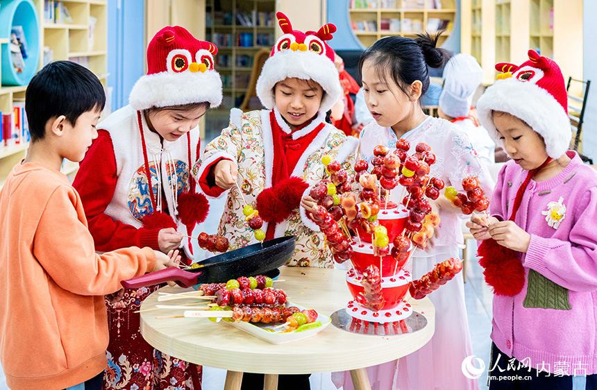 呼和浩特市玉泉区南柴火市街小学学生在学习制作糖葫芦。丁根厚摄
