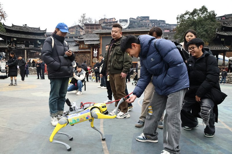 4图为游客在与智能机器狗握手互动.JPG