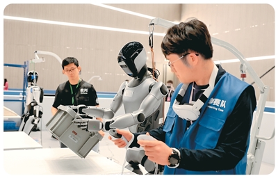 5月29日，2025国际人形机器人技能大赛在2025张江具身智能开发者大会上正式启动。图为机器人在进行工业场景料箱搬运比赛。   新华社记者 方 喆摄