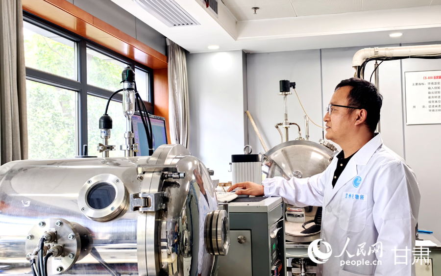 中国科学院兰州化学物理研究所实验室内,研究人员正在查看相关监测数据。人民网记者 高翔摄