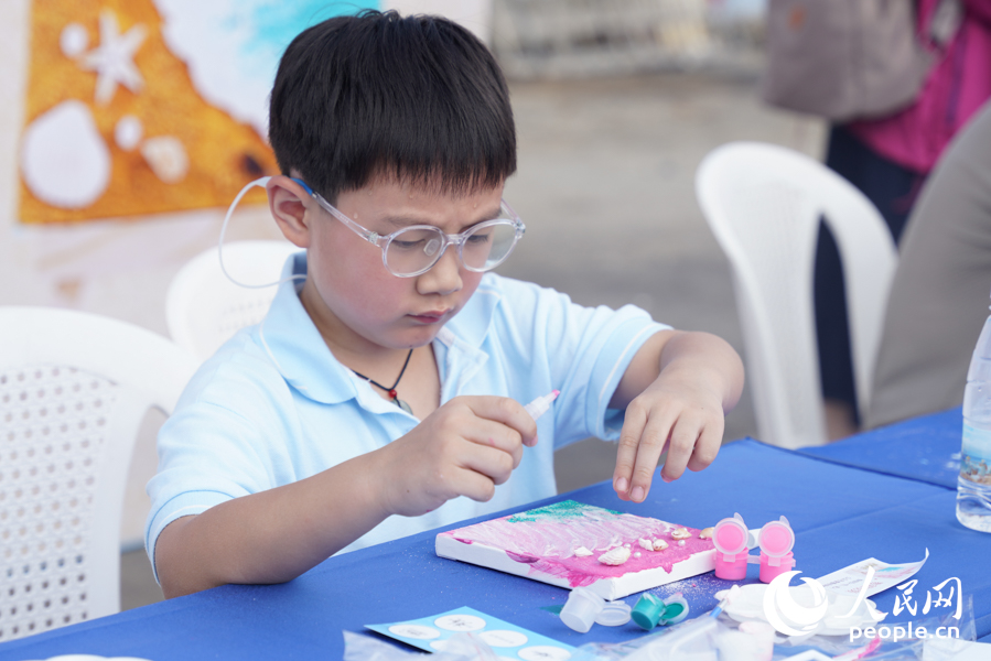 孩子在创作贝壳画。实习生 郑舒尘摄