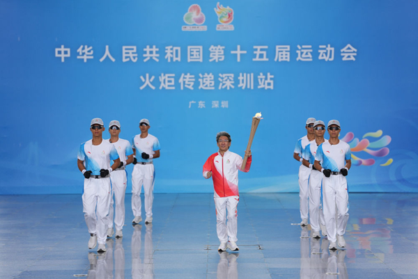 火炬手薛其坤(中)手持火炬起跑。新华社记者 江汉 摄