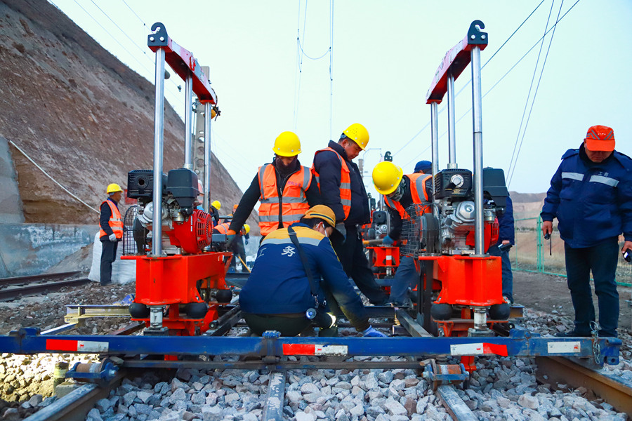 兰州西工务段职工在包兰线水源站对清筛后的道岔进行人工捣固作业。王光辉摄