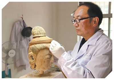 图为敦煌研究院壁画保护修复专家正在进行彩塑修复。受访者供图