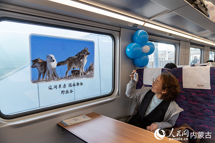 旅客在首发动车组列车上打卡拍照。郑焱摄