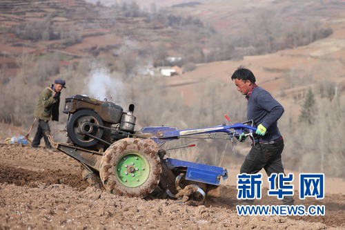 3月10日,在渭源县元古堆村,路彦荣推着新式手扶拖拉机和村民一起干