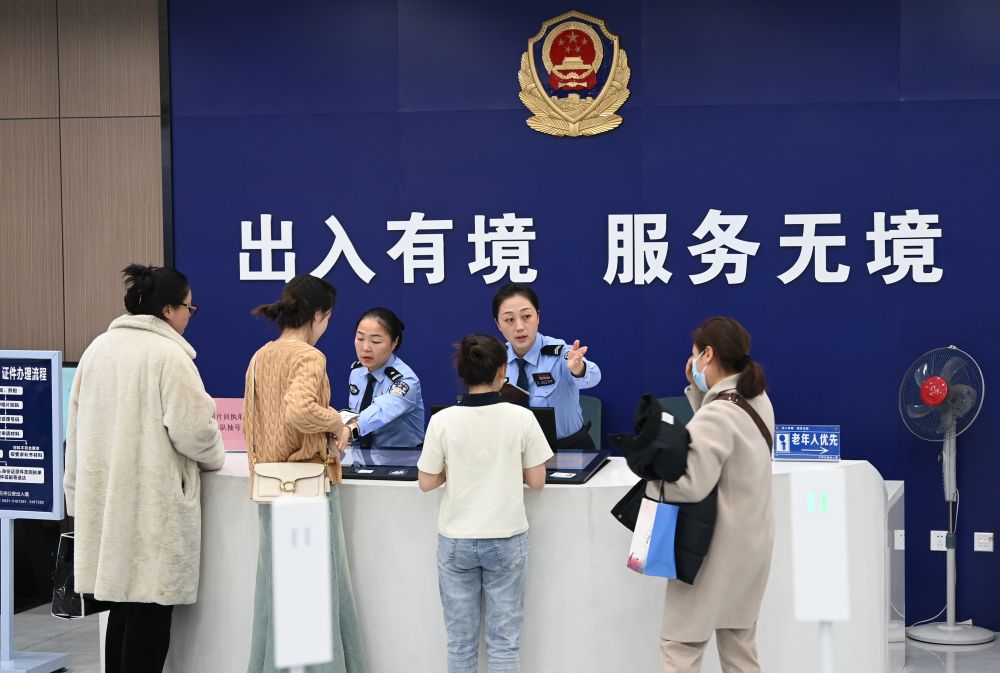 兰州市公安局出入境管理处办证大厅,工作人员正在有序引导群众办理