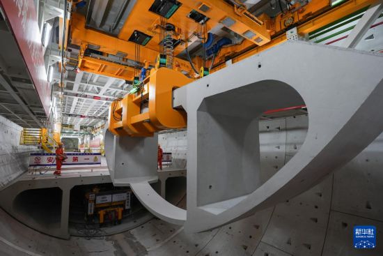 5月29日，中铁十四局技术人员在甬舟铁路金塘海底隧道“甬舟号”盾构机内操作箱涵吊机拼装弧形构件。新华社记者 黄宗治 摄