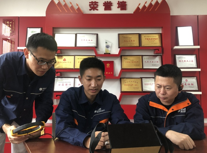 刘传波（中）与同事研讨技术创新方案。人民网记者 王斯文摄