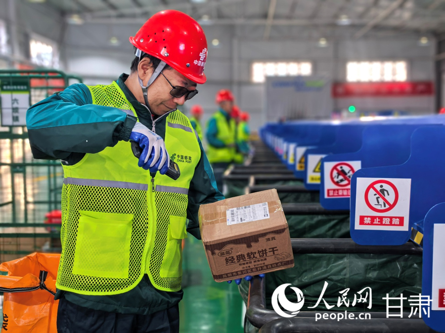 永昌县寄递物流共配中心，邮政分拣员梁玉顺正在查验和分拣快递包裹。人民网记者 高翔摄